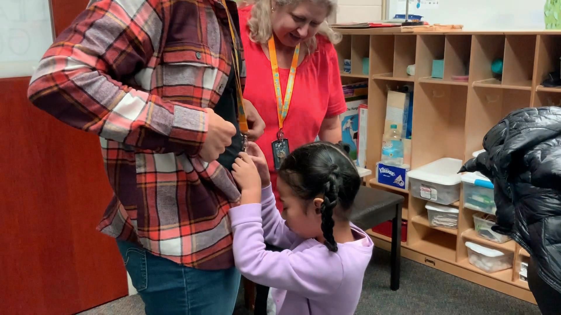 Girl who is blind reaches to grab a lanyard.