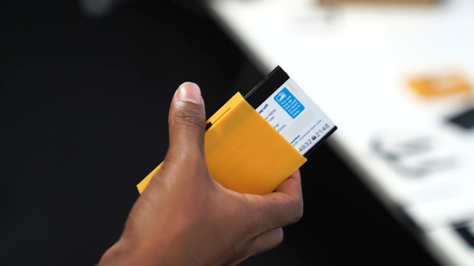 A hand holding a 3D printed wallet designed for users with arthritis.